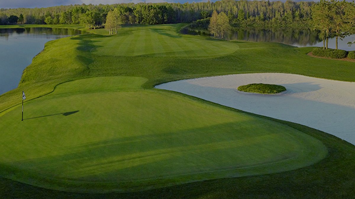 Green beside a lake and bunker at Falcon's Fire Golf Club in Kissimmee