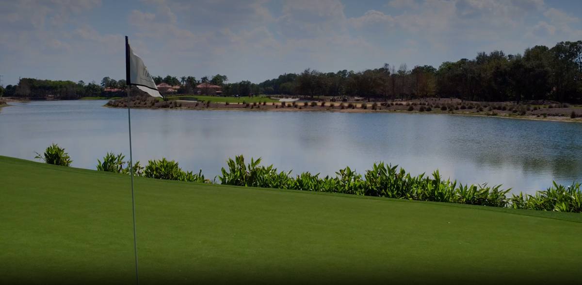Flag on a green beside a lake at Tiburon Golf Club in Naples
